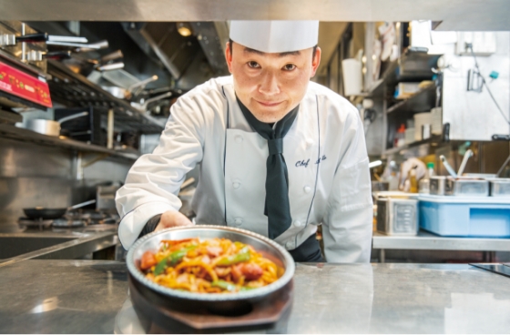 厨房から出来上がった料理を出しているスタッフの写真