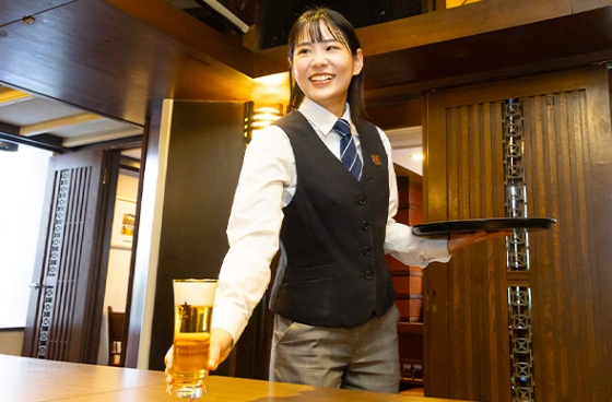 客席に生ビールを提供しているスタッフの写真